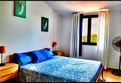 a bedroom with a bed with blue sheets and a window at Andreia in Santa Maria