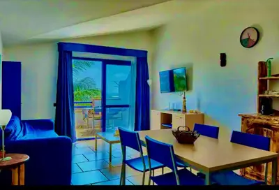 a living room with a table and a blue couch at Andreia in Santa Maria