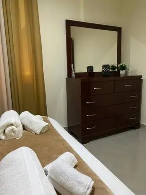 a bedroom with a dresser and towels on a bed at T1 Férias Mindelo in Mindelo