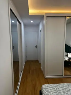 a bedroom with white walls and a door with a mirror at ROYAL PALMAREJO APPARTAMENTO in Praia