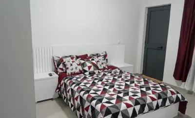 a bedroom with a bed with a black and white comforter at Pinto’s in Praia