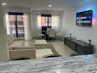a living room with a couch and a tv in a room at Pinto’s in Praia