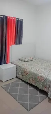 a bedroom with a bed and a table and a curtain at Pinto’s in Praia