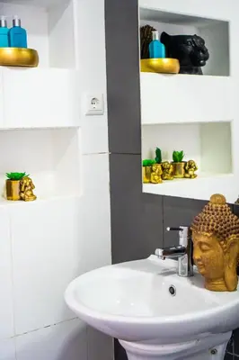 a bathroom with a sink with a statue on it at Morabezahome - Zaza in Mindelo