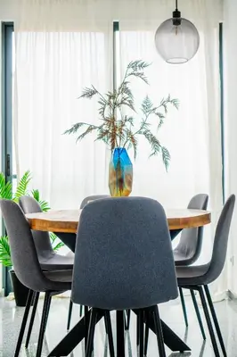 a dining room table with chairs and a vase with a plant at Morabezahome - Zaza in Mindelo