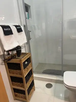 a bathroom with a shower and a table with towels at NEW Luxury Condo - In the heart of Santa Maria in Santa Maria
