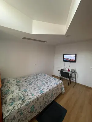 a bedroom with a bed and a flat screen tv at Casa Mendes- Quarto Casal in Praia