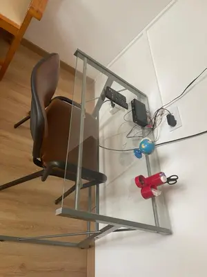 a glass desk with a chair under a glass table at Casa Mendes- Quarto Casal in Praia