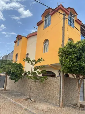 a yellow building with a brick wall and trees at Casa Mendes- Quarto Casal in Praia
