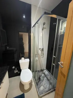 a bathroom with a toilet and a glass shower at Casa Mendes- Quarto Casal in Praia