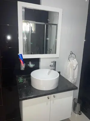 a bathroom with a white sink and a mirror at Casa Mendes- Quarto Casal in Praia