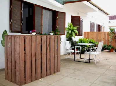 a wooden fence in front of a patio with a table at Syd's Guesthouse in Praia