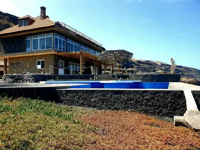 a house on top of a stone wall at Hotel Salinas São Jorge in São Filipe