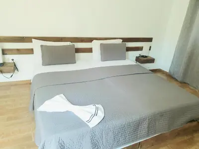a bedroom with a large bed with a gray blanket at Hotel Salinas São Jorge in São Filipe