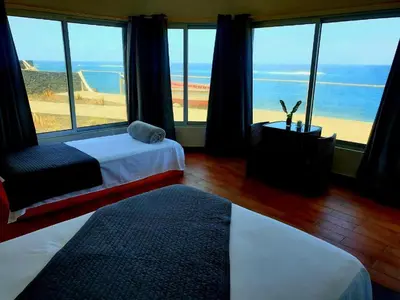 a bedroom with two beds and a view of the ocean at Hotel Salinas São Jorge in São Filipe