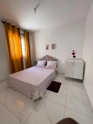 a bedroom with a bed and a dresser in it at house of happiness in Praia