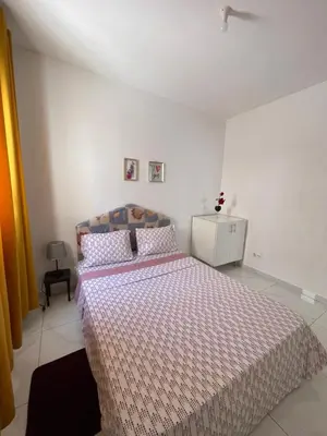 a bedroom with a large bed with a comforter at house of happiness in Praia