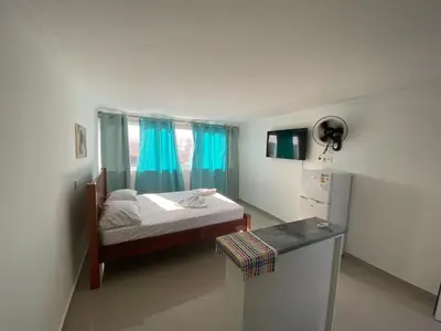 a bedroom with a bed and a window with blue curtains at My Flat 0 in Praia