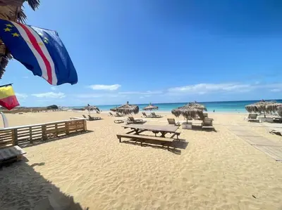 a beach with chairs and umbrellas and the ocean at Salty Apartments in Santa Maria