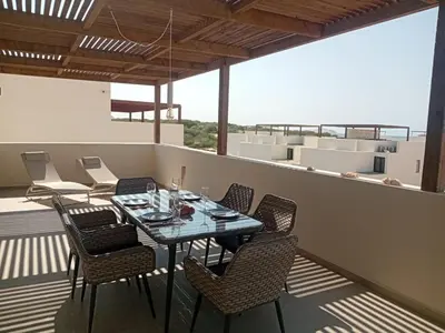 a patio with a table and chairs on a balcony at Vila Cristina Alojamento, Praia Estoril, Boa Vista in Sal Rei