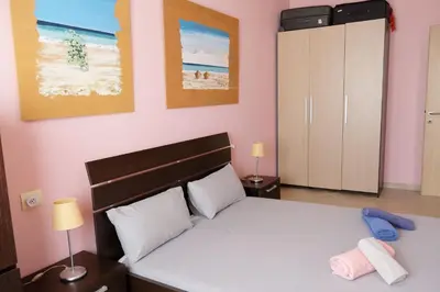 a bedroom with a white bed and a pink wall at Nagoia's place com varanda, piscina e super wi-fi in Santa Maria