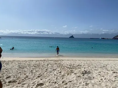 a man standing on a beach in the water at Muralha Rooms in Mindelo