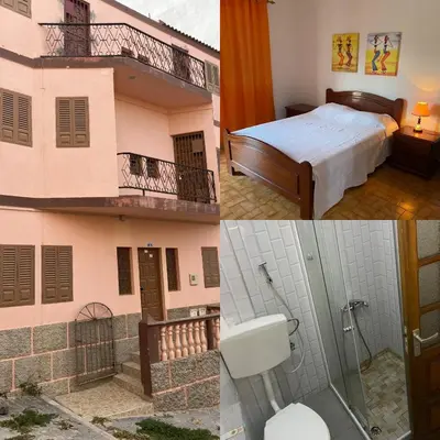 a hotel room with a bed and a balcony at Muralha Rooms in Mindelo
