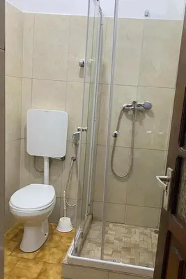 a bathroom with a toilet and a shower at Muralha Rooms in Mindelo