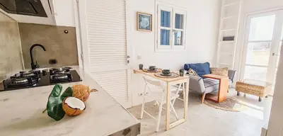 a kitchen with a counter top and a table at Chic Surf-Inspired Mezzanine Studio 