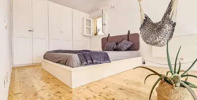 a bedroom with a bed and a potted plant at Chic Surf-Inspired Mezzanine Studio 
