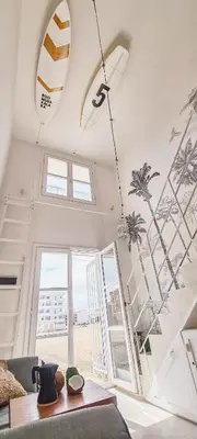 a room with a surfboard mural on the wall at Chic Surf-Inspired Mezzanine Studio 