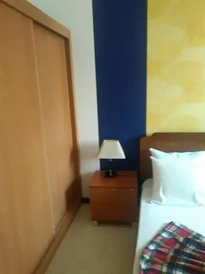 a bedroom with a bed and a lamp on a night stand at Apartamentos Santiago - Praia in Praia