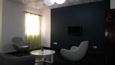 a room with two chairs and a table and a tv at Apartamentos Santiago - Praia in Praia