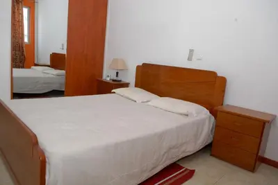 a bedroom with a large bed and a mirror at Apartamentos Santiago - Praia in Praia