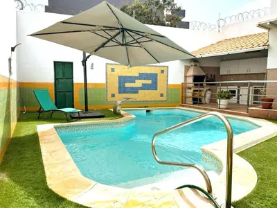 a pool with an umbrella and a chair and a table at wonder of the archipelago in Praia