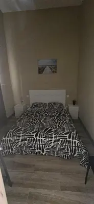 a bed with a black and white comforter in a bedroom at City Center Mindelo 39 in Mindelo