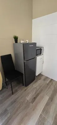 a chair and a refrigerator in a room at City Center Mindelo 39 in Mindelo