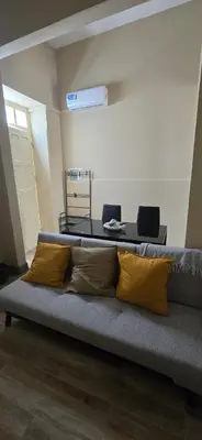 a couch with pillows on it in a living room at City Center Mindelo 39 in Mindelo