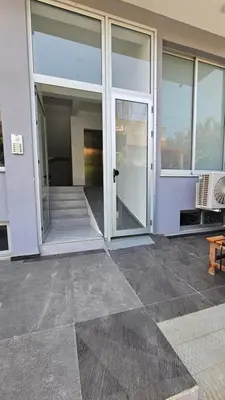 a large building with glass doors and a porch at Apartamento Batuku in Praia