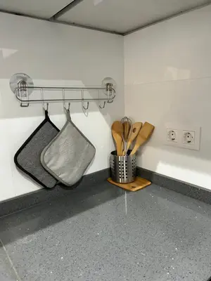 a kitchen with a counter with utensils on a wall at Apartamento Ilhas in Praia