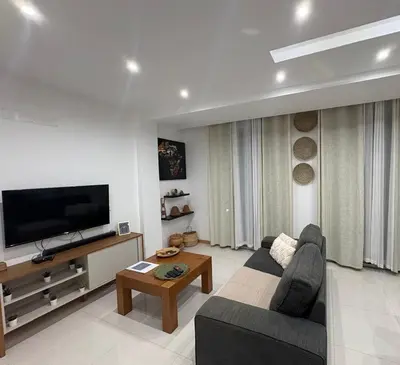 a living room with a couch and a flat screen tv at Apartamento Ilhas in Praia