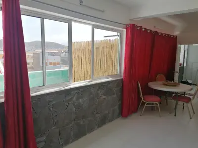 a living room with red curtains and a table and window at STUDIO VUE MER - CASA da LUZ in Mindelo