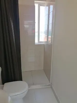 a bathroom with a shower with a toilet and a window at STUDIO VUE MER - CASA da LUZ in Mindelo