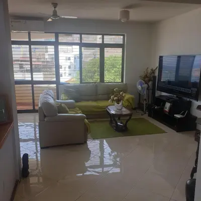 a living room with a couch and a tv at Gamboa Praia in Praia