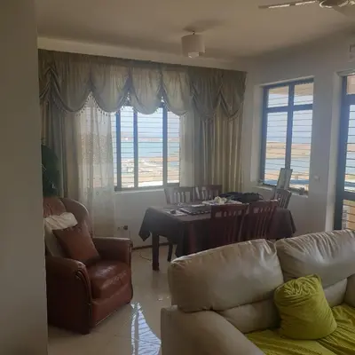a living room with a couch and a table and chairs at Gamboa Praia in Praia