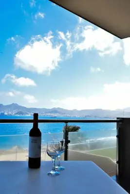 a bottle of wine sitting on a table with a glass at Duarte Apartments - Las Rochas in Mindelo