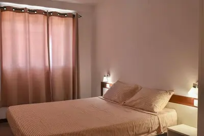 a bedroom with a bed with a curtain and a bed sidx sidx sidx at Duarte Apartments - Las Rochas in Mindelo