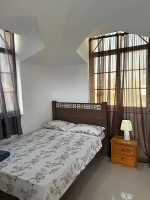 a bedroom with a bed and a table with a lamp at Casa Mendes- Quarto individual in Praia