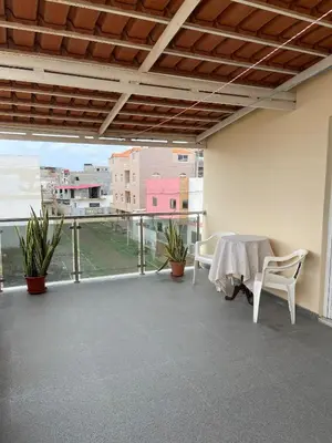 a room with a table and chairs on a balcony at Casa Mendes- Quarto individual in Praia