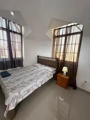a bedroom with a bed and two windows at Casa Mendes- Quarto individual in Praia